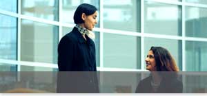 image: two women in business attire talking to each other